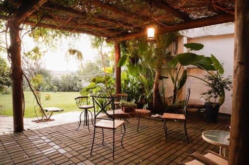 a patio with chairs and a table and some plants at Rodeio Hotel in Rodeio Bonito