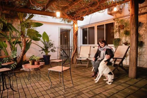 a woman sitting on a chair with a dog at Rodeio Hotel in Rodeio Bonito