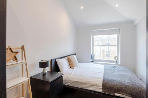 a white bedroom with a bed and a window at Marylebone Gloucester Place Apartments in London