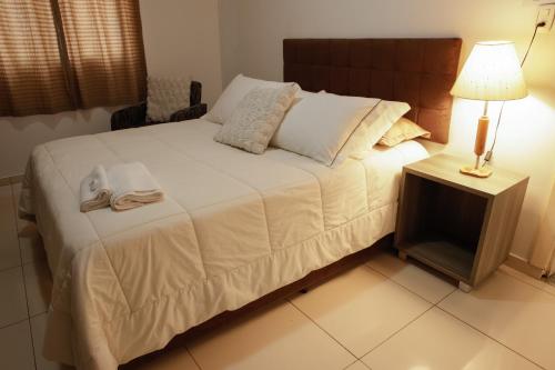 a bedroom with a bed with a lamp and a table at Rodeio Hotel in Rodeio Bonito