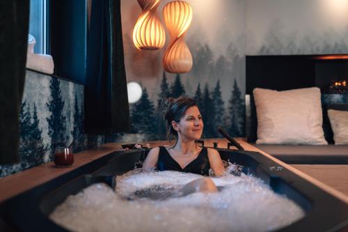 a woman is sitting in a bath tub at Domaine Des Hautes Fagnes in Ovifat