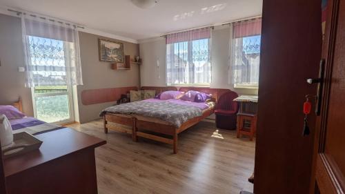 a bedroom with a bed and a table and windows at Baltazar in Łeba