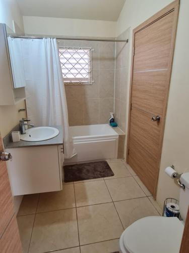 a bathroom with a tub and a sink and a toilet at Chad's Island Retreat in Spanish Town