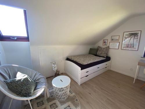 a small bedroom with a bed and a chair at Privates neu renoviertes Zimmer in Schwaig in Schwaig bei Nürnberg