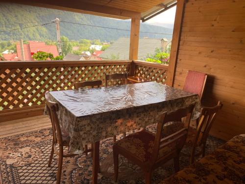 una mesa y sillas en el balcón de una cabaña en Svitlyachok, en Yaremche