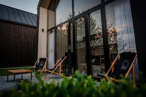a group of chairs sitting in front of a building at Czarne Domki in Zwierzyniec