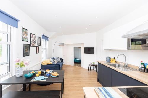 a kitchen and living room with a table and a counter at Sleep 10- The Lovely Lymington Lock off. in Lymington