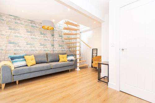 a living room with a couch and a brick wall at Sleep 10- The Lovely Lymington Lock off. in Lymington