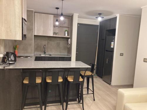 a kitchen with a counter and bar stools at Piso11 Concepcion in Concepción