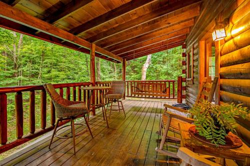 a porch of a cabin with chairs and a table at Sweet Fantasy in Sevierville