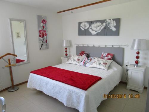 a bedroom with a bed with a red and white blanket at les palmiers in Vias