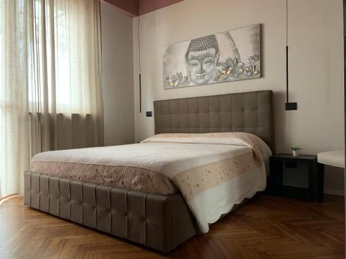 a bedroom with a large bed with a picture on the wall at La Favola Apartment Orbassano in Orbassano