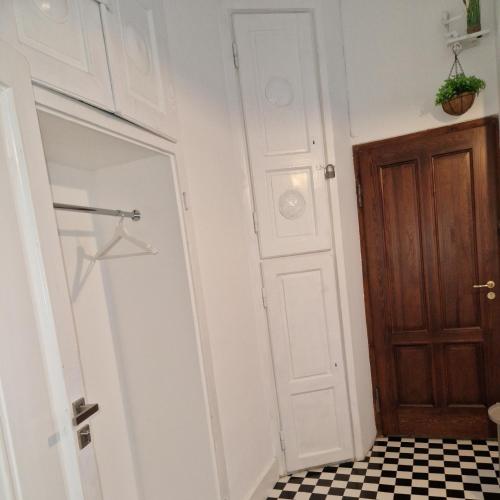 a bathroom with a door and a black and white tile floor at Pokoje gościnne na Lwowskiej in Warsaw