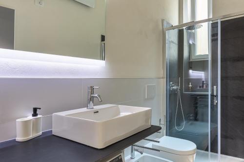 a white bathroom with a sink and a toilet at La Boutique Milano: appartamento in Porta Romana in Milan