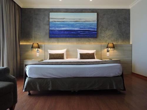 a hotel room with a large bed with two lamps at BFC Suíte em Barra da Tijuca in Rio de Janeiro
