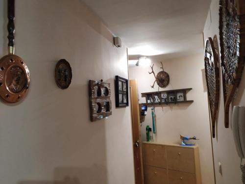 a hallway with clocks on the wall and a cabinet at Apartamento en Escarrilla, sallent de gallego in Sallent de Gállego