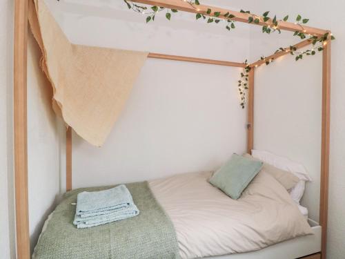 a bed with a wooden frame with a blanket on it at Islestone, 1 Temperance Terrace in Berwick-Upon-Tweed