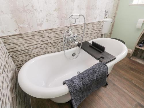 a bathroom with a white bath tub and a sink at Islestone, 1 Temperance Terrace in Berwick-Upon-Tweed