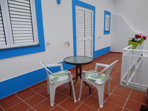 a table and chairs in a room with blue and white walls at SUDWEST ROOMS by Stay in Alentejo for HIKERS in Vila Nova de Milfontes