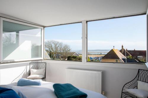 a bedroom with a bed and a large window at Coastguard Cottage in Milford on Sea