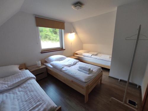 1 dormitorio con 2 camas y ventana en Domek u Hornika, en Dursztyn