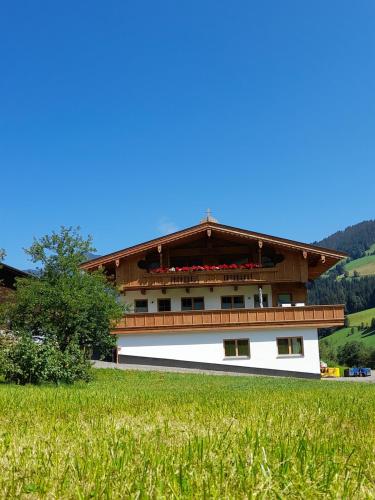 a building with a balcony on the side of a field at Ferienwohnungen Lehenhof in Alpbach
