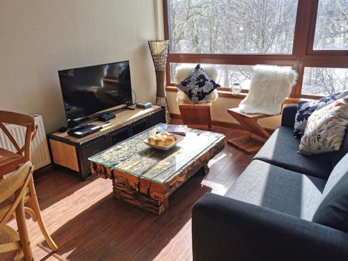 a living room with a couch and a coffee table at DEPARTAMENTOS TERMAS DE CHILLAN in Nevados de Chillan