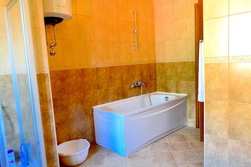 a bathroom with a white tub and a toilet at Apartments Risan Club Family in Risan