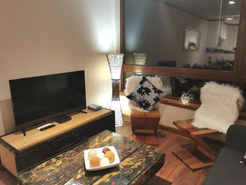 a living room with a large flat screen tv at DEPARTAMENTOS TERMAS DE CHILLAN in Nevados de Chillan