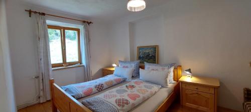 a bedroom with a bed with pillows and a window at Graslandhof in Neumarkt in Steiermark