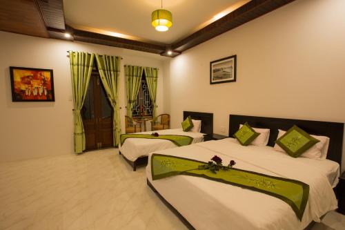 a hotel room with two beds in a room at The Village Homestay in Hoi An