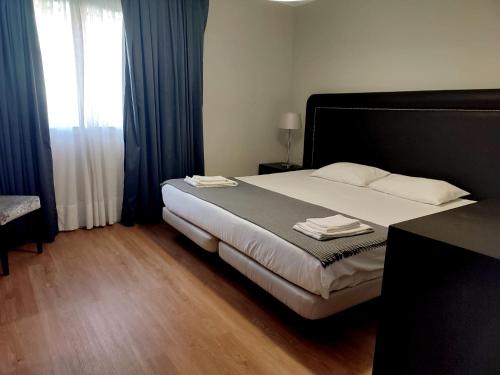 a bedroom with a large bed and a window at Vila Hotel By VimaHotels in Guimarães