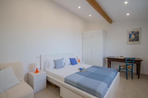 um quarto branco com uma cama azul e uma secretária em Settentrione Apartment em Chiavari