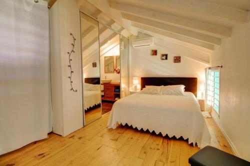 sypialnia z dużym białym łóżkiem i lustrem w obiekcie Crystal Beach Appart vue mer 7 à 9p, accès direct plage et piscine w mieście Sèze