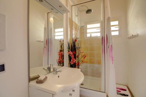 a bathroom with a sink and a mirror at Crystal Beach, vue mer, accès direct plage et piscine, clim in Sèze