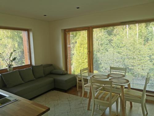 a living room with a couch and a table and chairs at Vytauto 423 Apartments by JK in Palanga