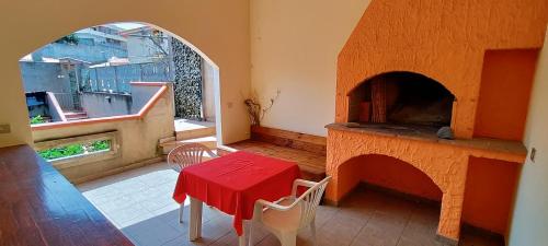 a room with a table and a red table and a fireplace at Grazioso e confortevole attico, costa sud-ovest in Gonnesa