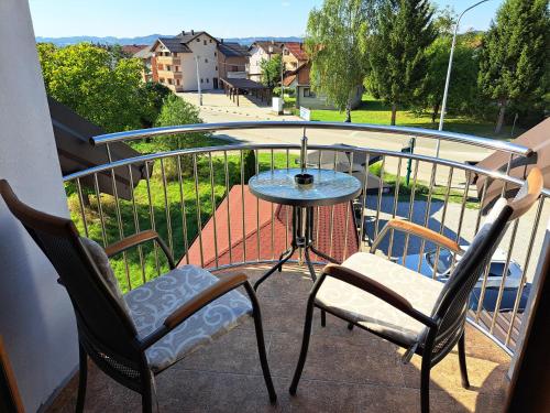 a balcony with two chairs and a table on a balcony at Apartman Bubic in Banja Vrućica