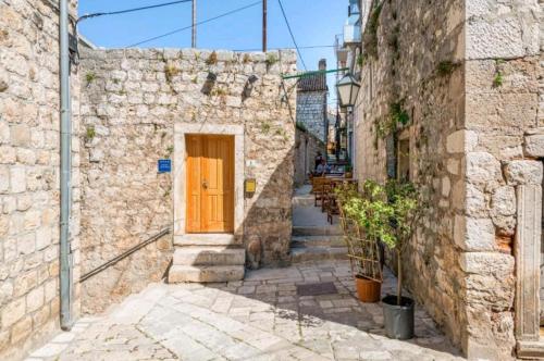 a stone alley with a yellow door in a building at Vintage house al pozzo in Hvar