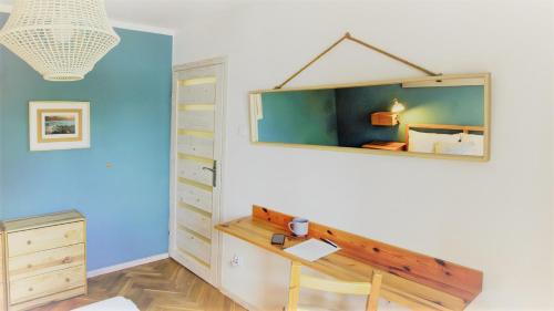 Cette chambre comprend un bureau et un miroir mural. dans l'établissement Casa del Mare, Apartments and more, à Łeba