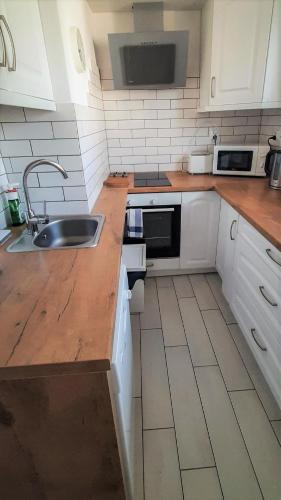 a kitchen with a sink and a wooden counter top at Casa del Mare, Apartments and more in Łeba