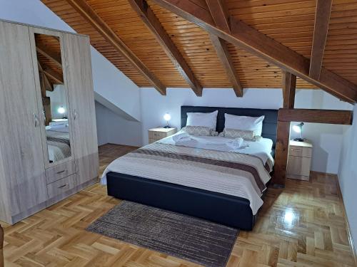 a bedroom with a large bed and wooden ceilings at Apartman Bubic 