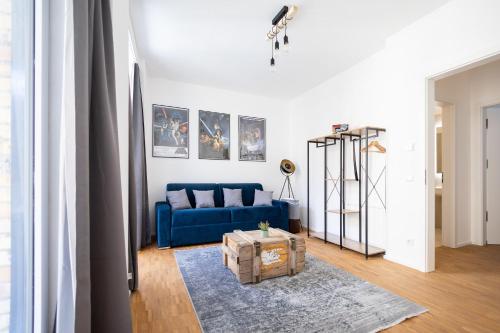 - un salon avec un canapé bleu et une table dans l'établissement Ko-Living - Gaming Suite am Alten Markt - Altstadt - 6P, à Halle-sur-Saale