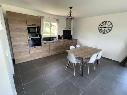 une cuisine et une salle à manger avec une table et des chaises dans l'établissement Gîte Gentil, à La Chapelle-de-la-Tour