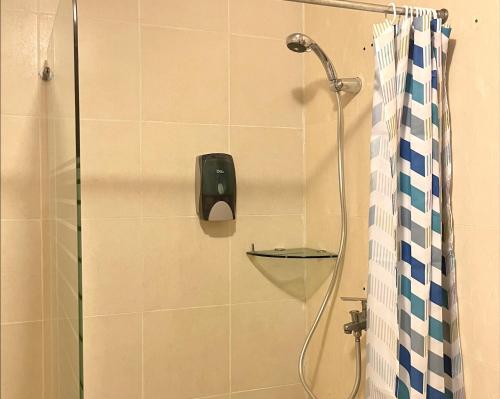 a shower in a bathroom with a shower head at Kirin Guesthouse and Restaurant in Port Louis