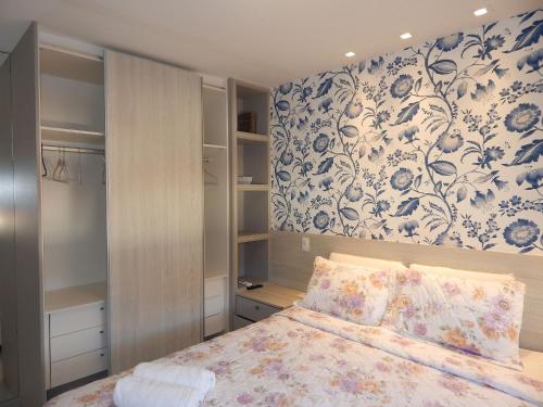 Un dormitorio con una cama con papel pintado floral. en Linda e aconchegante casa a 400m da Praia de Geribá com Piscina - B35, en Búzios