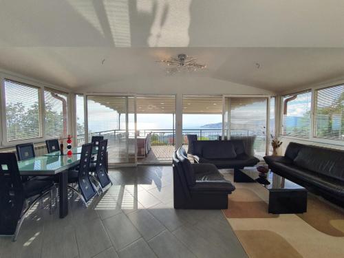 a living room with a couch and a table and chairs at Villa Aurora in Ohrid