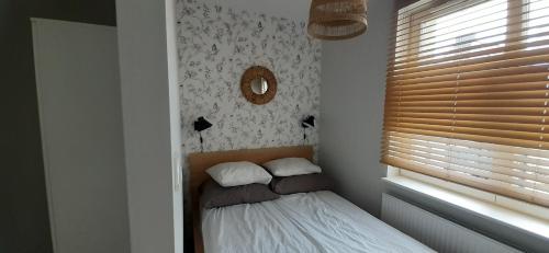 a small bedroom with a bed and a window at Oasis, Old Town Apartment in Elblag