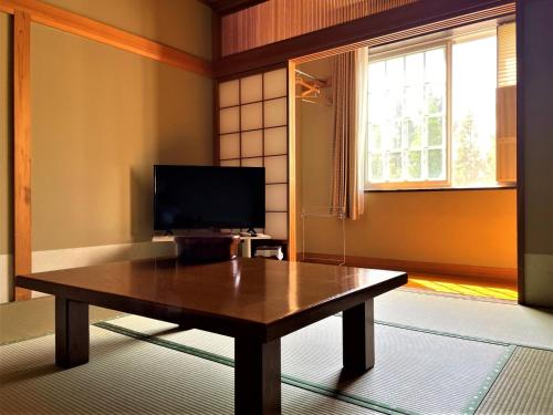 a living room with a wooden table and a television at Koguriyama Sanso - Vacation STAY 16071v in Minami Uonuma