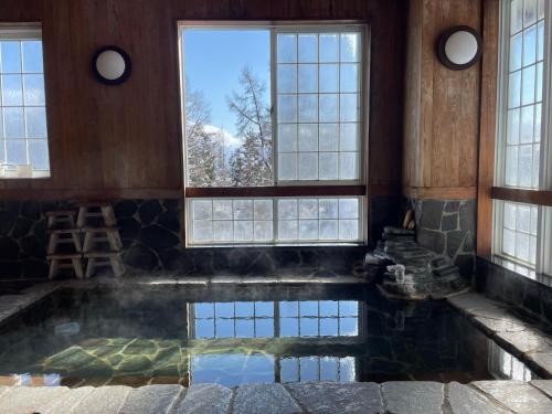 einen Pool mit Wasser in einem Zimmer mit Fenstern in der Unterkunft Koguriyama Sanso - Vacation STAY 16071v in Minami Uonuma